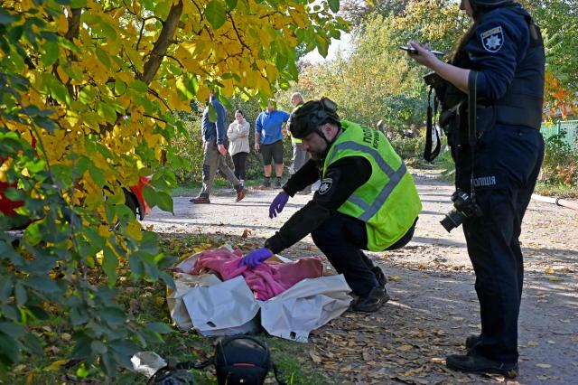 Police experts examines the body of a woman killed in a private house following a Russian guided aerial bomb attack in Kharkiv, on October 11, 2026, amid the Russian invasion of Ukraine. (Photo by SERGEY BOBOK / AFP)