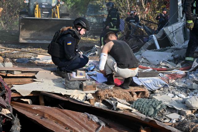 A local resident searches for documents in the ruins of private houses destroyed following a Russian guided aerial bomb attack that killed one person, amid the Russian invasion of Ukraine, in Kharkiv on October 11, 2026. (Photo by SERGEY BOBOK / AFP)