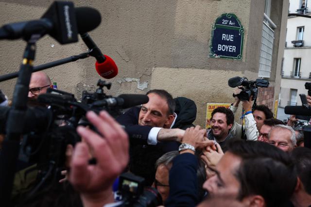 Candidate in the Socialist (PS) and centre-left Place Publique (PP) parties primary Raphael Glucksmann (C) arrives after the announcement of the result for the first round of voting in the primary organized by the Socialist Party, Place Publique (PP), and the Republican and Socialist Left, ahead of France's 2027 presidential election, in Paris on October 11, 2026. Candidate in the Socialist (PS) and centre-left Place Publique (PP) parties primary ahead of France's 2027 presidential election and MEP Raphaël Glucksmann was elected on October 11, 2026 as the Social Democratic lefts candidate for the French presidential election, winning more than 66 percent of the vote in the first round of a primary election that drew 120,787 voters, organizers announced. (Photo by ROMAIN PERROCHEAU / AFP)