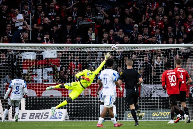 Auxerre's Mauritanian goalkeeper #23 Mamadou Diop (2L) dives unsuccessfully to stop the ball for Rennes' second goal during the French L1 football match between Stade Rennais FC and AJ Auxerre at the Roazhon Park Stadium in Rennes, western France on October 11, 2026. (Photo by Guillaume SALIGOT / AFP)