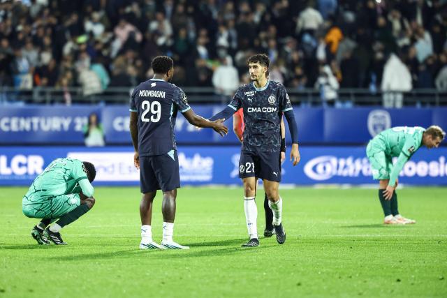 Marseille's Moroccan defender #21 Nayef Aguerd (R) and Marseille's Cameroonian forward #29 Faris Moumbagna celebrate after winning the French L1 football match between ES Troyes AC and Olympique de Marseille (OM) at the Stade de l'Aube in Troyes, central France, on October 11, 2026. (Photo by Sameer Al-DOUMY / AFP)