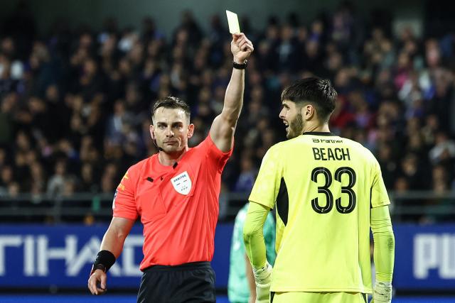 Troyes' Australian goalkeeper #33 Patrick Beach (R) receives a yellow card during the French L1 football match between ES Troyes AC and Olympique de Marseille (OM) at the Stade de l'Aube in Troyes, central France, on October 11, 2026. (Photo by Sameer Al-DOUMY / AFP)