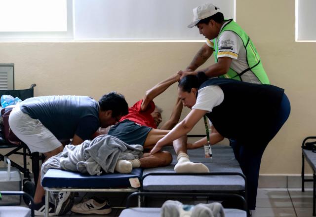 Medical personnel attend to a person who voluntarily evacuated their home due to the risk of flooding and sought shelter at a municipal DIF facility in Puerto Vallarta, Jalisco state, Mexico, on October 11, 2026. Hurricane Simon strengthened into a powerful Category 4 storm and was expected to make landfall or skirt the coast of west-central Mexico on October 11, 2026, according to the US National Hurricane Center. (Photo by ULISES RUIZ / AFP)