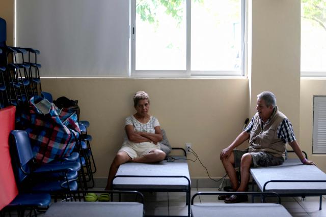 A couple who voluntarily evacuated their home due to the risk of flooding takes shelter ahead of the expected impact of Hurricane Simon at a municipal DIF facility in Puerto Vallarta, Jalisco state, Mexico, on October 11, 2026. Hurricane Simon strengthened into a powerful Category 4 storm and was expected to make landfall or skirt the coast of west-central Mexico on October 11, 2026, according to the US National Hurricane Center. (Photo by ULISES RUIZ / AFP)