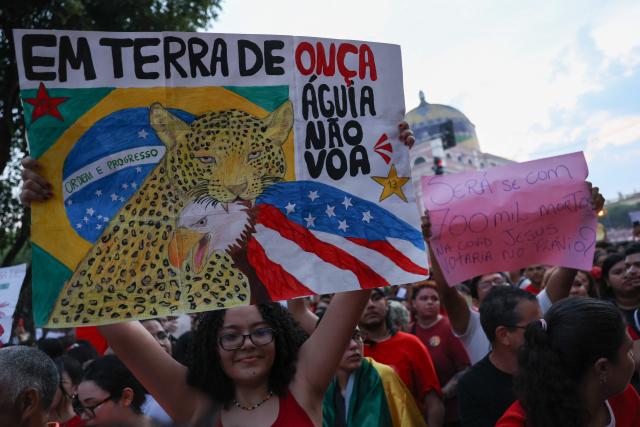 A supporter of Brazilian President and presidential candidate Luiz Inacio Lula da Silva of the Workers' Party (PT) hold a banner reading "In the land of jaguars, the eagle does not fly" during a rally in downtown Manaus, in the state of Amazonas, northern Brazil, on October 11, 2026, ahead of the presidential election. (Photo by MICHAEL DANTAS / AFP)