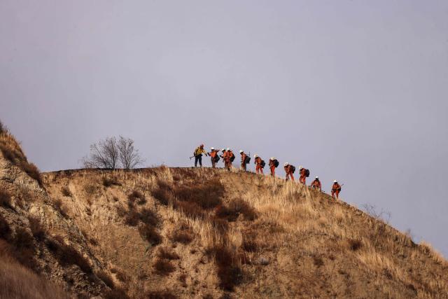 Firefighters climb a ridge while fighting the Bike fire in the outskirts of Santa Clarita, California on October 11, 2026. Los Angeles County Fire is battling a fast moving wildfire that started on Sunday afternoon threatening homes in Santa Clarita, the third largest city in Los Angeles County. The LA County Sheriff's office ordered residents to evacuate as the Bike fire grew to 100 acres in size in a very short time. (Photo by David Swanson / AFP)