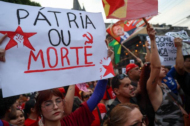 A supporter of Brazilian President and presidential candidate Luiz Inacio Lula da Silva of the Workers' Party (PT) hold a banner reading “Homeland or death” during a rally in downtown Manaus, in the state of Amazonas, northern Brazil, on October 11, 2026, ahead of the presidential election. (Photo by MICHAEL DANTAS / AFP)