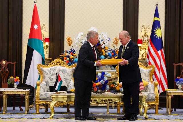 Malaysia's King Sultan Ibrahim Sultan Iskandar (R) gives a gift to Jordan's King Abdullah II at the National Palace in Kuala Lumpur on October 12, 2026. (Photo by Hasnoor Hussain / POOL / AFP)