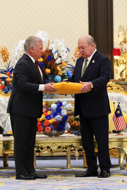 Malaysia's King Sultan Ibrahim Sultan Iskandar (R) gives an award to Jordan's King Abdullah II at the National Palace in Kuala Lumpur on October 12, 2026. (Photo by Hasnoor Hussain / POOL / AFP)