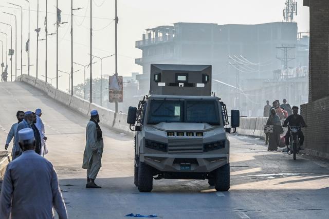 Armoured police vehicles drive along a road as security tightened after the imposition of an emergency rule in Peshawar on October 12, 2026 following anti-government demonstrations by the opposition Pakistan Tehreek-e-Insaf (PTI) party demanding the release of jailed former prime minister Imran Khan. Pakistan placed a northern province under emergency rule on October 12, the president's office said, following anti-government demonstrations by supporters of jailed former prime minister Imran Khan and militant violence in the northwest. (Photo by Abdul MAJEED / AFP)