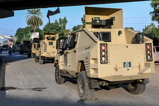 Armoured police vehicles drive along a road as security tightened after the imposition of an emergency rule in Peshawar on October 12, 2026 following anti-government demonstrations by the opposition Pakistan Tehreek-e-Insaf (PTI) party demanding the release of jailed former prime minister Imran Khan. Pakistan placed a northern province under emergency rule on October 11, the president's office said, following anti-government demonstrations by supporters of jailed former prime minister Imran Khan and militant violence in the northwest. (Photo by Abdul MAJEED / AFP)