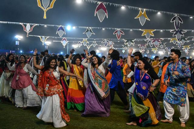 People wearing traditional dresses perform the 'Garba' dance as part of the annual Hindu festival of Navratri at the Laxmi Vilas Palace in Vadodara on October 11, 2026. (Photo by Noah SEELAM / AFP)