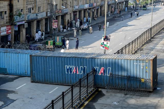 People walk along a blocked road after the imposition of an emergency rule in Peshawar on October 12, 2026 following anti-government demonstrations by the opposition Pakistan Tehreek-e-Insaf (PTI) party demanding the release of jailed former prime minister Imran Khan. Pakistan placed a northern province under emergency rule on October 11, the president's office said, following anti-government demonstrations by supporters of jailed former prime minister Imran Khan and militant violence in the northwest. (Photo by Abdul MAJEED / AFP)