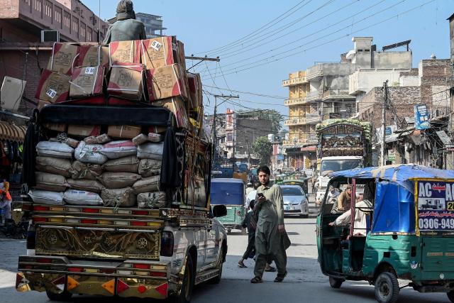 People travel along a road at the Hastnagri Gate after the imposition of an emergency rule in Peshawar on October 12, 2026 following anti-government demonstrations by the opposition Pakistan Tehreek-e-Insaf (PTI) party demanding the release of jailed former prime minister Imran Khan. Pakistan placed a northern province under emergency rule on October 11, the president's office said, following anti-government demonstrations by supporters of jailed former prime minister Imran Khan and militant violence in the northwest. (Photo by Abdul MAJEED / AFP)