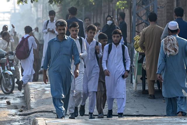 Students walk back to their homes as schools are closed after the imposition of an emergency rule in Peshawar on October 12, 2026 following anti-government demonstrations by the opposition Pakistan Tehreek-e-Insaf (PTI) party demanding the release of jailed former prime minister Imran Khan. Pakistan placed a northern province under emergency rule on October 11, the president's office said, following anti-government demonstrations by supporters of jailed former prime minister Imran Khan and militant violence in the northwest. (Photo by Abdul MAJEED / AFP)