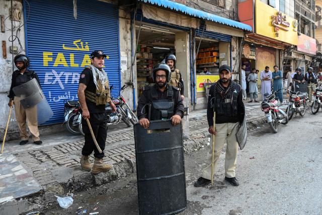 Police personnel stand guard along a street after the imposition of an emergency rule in Peshawar on October 12, 2026 following anti-government demonstrations by the opposition Pakistan Tehreek-e-Insaf (PTI) party demanding the release of jailed former prime minister Imran Khan. Pakistan placed a northern province under emergency rule on October 11, the president's office said, following anti-government demonstrations by supporters of jailed former prime minister Imran Khan and militant violence in the northwest. (Photo by Abdul MAJEED / AFP)