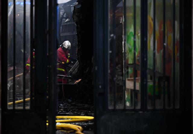 Firefighters work to extinguish a fire at «Le marche des Enfants Rouges» (Red Children market) center of Paris on October 12, 2026. (Photo by JULIEN DE ROSA / AFP)