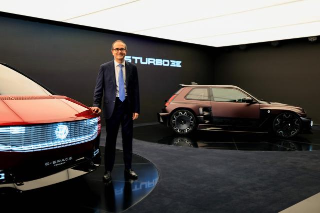 CEO of French car maker Renault Group, Francois Provost, poses next to a Renault E-Space Concept car (L) and a Renault R5 Turbo car during the 91st edition of the international Paris Motor Show at the Porte de Versailles in Paris on October 12, 2026. (Photo by Ludovic MARIN / AFP)