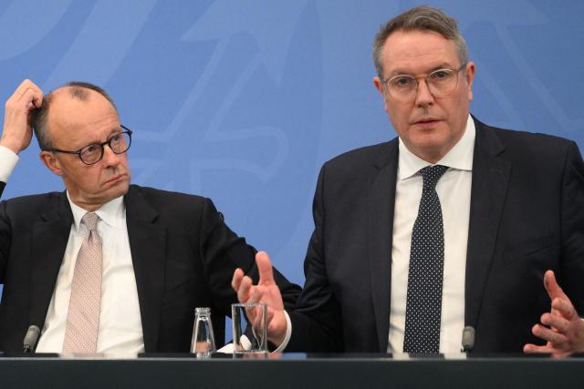 (FILES) German Chancellor Friedrich Merz (L) and then Rhineland-Palatinate's State Premier and member of Germany's Social Democratic Party (SPD) Alexander Schweitzer address a press conference following a meeting with the leaders of the country's federal states on December 4, 2025 at the Chancellery in Berlin. Following the resignation of Baerbel Bas (SPD) as Germany's labour minister, former Rhineland-Palatinate state premier Alexander Schweitzer (SPD) is to become her successor in the cabinet. This was confirmed to AFP by party sources on October 12, 2026. Bas had previously announced her resignation from the co-leadership of the party and from her ministerial post. (Photo by RALF HIRSCHBERGER / AFP)