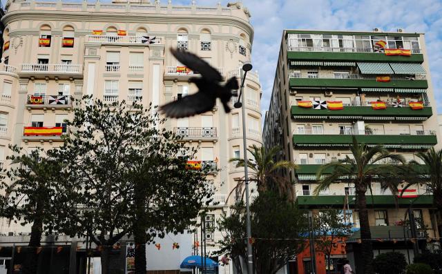 Spanish national flags hang on buildings' balconies in the city centre of the Spain's North African enclave of Ceuta on 11 October, 2026. Spain's King Felipe VI and Queen Letizia are scheduled to visit Ceuta on October 13, 2026. The Spanish North African enclave of some 80,000 inhabitants seek to regain balance while hundreds of migrants remain in makeshifts camp after the massive influx of tens of thousands of migrants from Morocco in late July. (Photo by Thomas COEX / AFP)