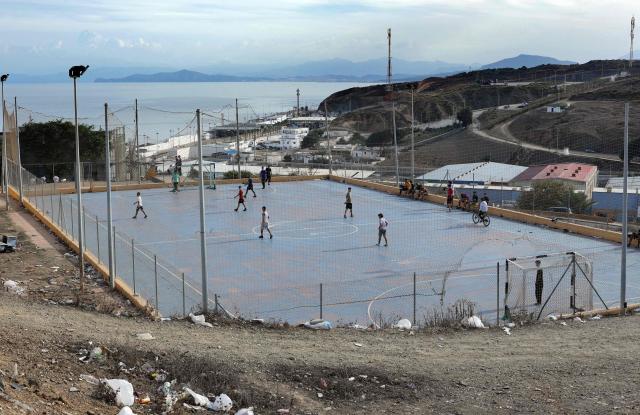 People living in the Principe Felipe neighbourhood play football in the Spain's North African enclave of Ceuta on 11 October, 2026. Spain's King Felipe VI and Queen Letizia are scheduled to visit Ceuta on October 13, 2026. The Spanish North African enclave of some 80,000 inhabitants seek to regain balance while hundreds of migrants remain in makeshifts camp after the massive influx of tens of thousands of migrants from Morocco in late July. (Photo by Thomas COEX / AFP)