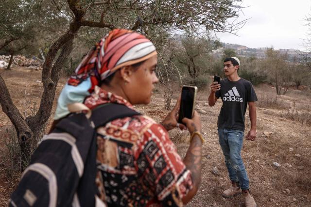 A foreign activist (L) attempts to prevent an Israeli settler from approaching an olive grove being harvested by Palestinian farmers near the village of Turmus Ayya, north of the city of Ramallah, in the Israeli-occupied Palestinian West Bank on October 12, 2026. The olive harvest starts in the West Bank in October and makes up a large component of the agricultural economy and cultural life for most Palestinians. Violence has flared in recent months in the West Bank with near-daily attacks, thefts or vandalism by Israeli settlers against Palestinians. Extremist Israeli settlers have been seizing olive groves owned by Palestinians, who see the trees as a cultural symbol. Some 500,000 Israeli settlers live in the West Bank, which Israel captured in 1967, among three million Palestinians. Settlements in occupied territory are illegal under international law.
 The olive harvest is a major component of the West Banks agricultural economy, rural livelihoods and cultural life. The Ministry of Agriculture estimates that around 750,000 dunums are planted with olive trees in the West Bank.  Olive trees make up about 45% to 48% of all agricultural land in the West Bank and Gaza, and account for roughly 70% of fruit production. (Photo by Zain JAAFAR / AFP)