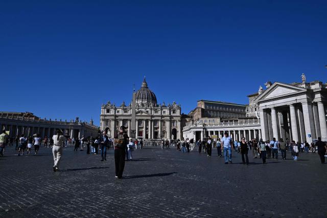 People walk at St Peter's square in the Vatican on October 12, 2026. Pope Leo XIV has said on October 11, 2026 he will have an operation to remove a lump on his lung this week, the first time a pope has made a personal medical announcement of this kind. (Photo by Tiziana FABI / AFP)