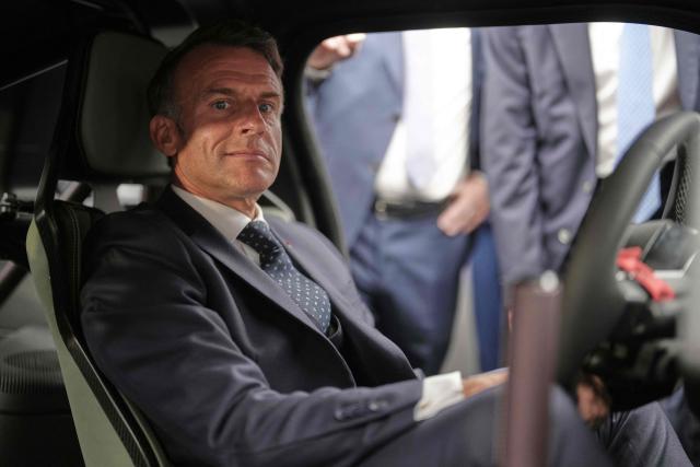 France's President Emmanuel Macron sits inside a Renault 5 Turbo 3E car as he visits Renault stand aduring the international Paris Motor Show at the Porte de Versailles in Paris on October 12, 2026. (Photo by Thibault Camus / POOL / AFP)