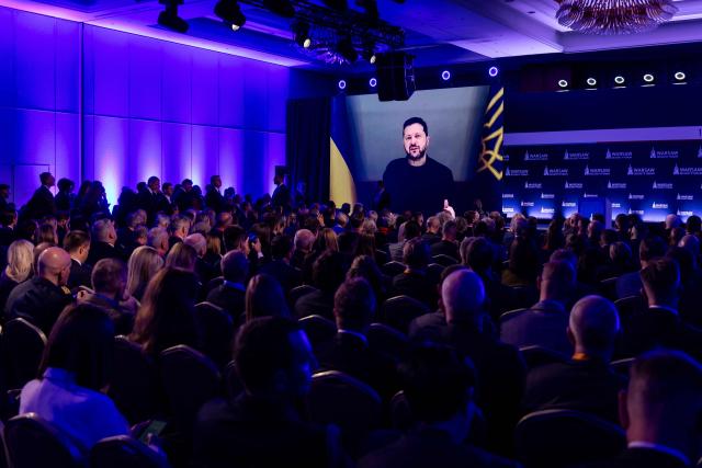 Participants listen as Ukraine's President Volodymyr Zelensky speaks via videolink during the opening session of the Warsaw Security Forum in Warsaw, Poland on October 12, 2026. (Photo by Wojtek RADWANSKI / AFP)