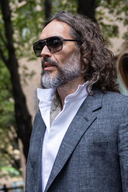 British comedian and actor Russell Brand leaves after jury selection finishes at the start of his trial at Southwark Crown Court in south London on October 12, 2026, after pleading not guilty to three charges of rape, indecent assault, and three counts of sexual assault. (Photo by Brook Mitchell / AFP)