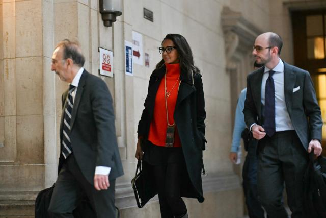 French television presenter Karine Le Marchand (C) arrives with her legal team at the Paris courthouse to attend a hearing in the appeal trial of celebrity press agent Mimi Marchand, , who is appealing her conviction for extortion against Le Marchand, in Paris, on October 12, 2026. (Photo by LOU BENOIST / AFP)