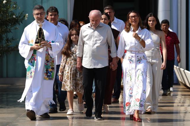 Brazil's President and presidential candidate Luiz Inacio Lula da Silva of the Workers' Party (PT), accompanied by first lady Rosangela "Janja" da Silva, leaves after a mass at the chapel of the Alvorada Palace marking the celebration of Brazil's patron saint, Our Lady of Aparecida, in Brasilia, Brazil, on October 12, 2026. (Photo by Sergio LIMA / AFP)