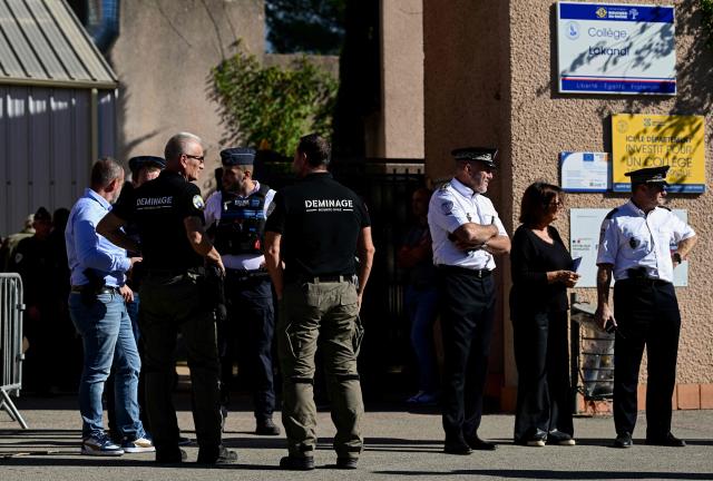 A bomb disposal team deploys to Joseph-Lakanal Middle School ahead of the arrival of France's Interior Minister and Education Minister after a headmaster was injured by a hunting rifle shot and a teenager was arrested in Aubagne, southern France on October 12, 2026. The school head was hit by a 12-gauge hunting rifle shot, the same source specified, adding that a member of the teaching staff was also hit. The victim's life is not in danger. (Photo by Miguel MEDINA / AFP)