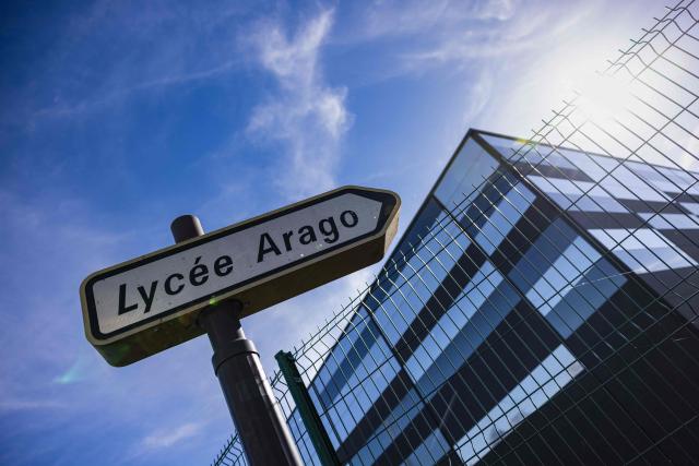 This photograph taken on October 12, 2026, shows a street sign bearing the name of the Francois Arago high school, where students carried out a blocking protest in Reims, northeastern France. In Reims, two members of the reception staff at Franзois Arago high school were injured by fireworks mortar rounds, according to multiple sources. “At least eight education staff members” were injured on the morning of October 12, 2026, amid protests by the high school student movement, the ministry said, noting that this figure did not include the middle school principal and the teacher injured by a shotgun blast in Aubagne. (Photo by Sameer Al-DOUMY / AFP)