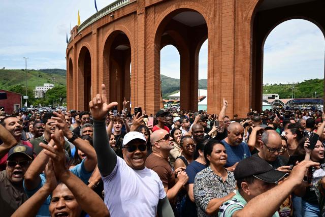 Supporters of Brazil's President and presidential candidate Luiz Inacio Lula da Silva chant slogans in support of Lula after attending a mass marking the celebration of Brazil's patron saint, Our Lady of Aparecida, at the National Shrine of Our Lady of Aparecida in Aparecida, Sao Paulo state, Brazil, on October 12, 2026. (Photo by Pablo PORCIUNCULA / AFP)