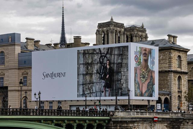 This photograph shows a large Saint Laurent advertising billboard on the facade of the Hôtel-Dieu hospital on Île de la Cité, near Notre-Dame Cathedral, in Paris on October 11, 2026. (Photo by JOEL SAGET / AFP)