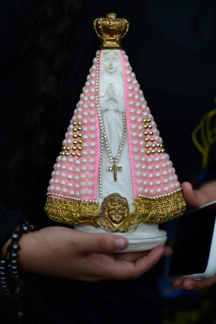 A Catholic devotee attends celebrations marking Our Lady of Aparecida Day at the Basilica of the National Shrine of Our Lady of Aparecida, Brazil's patron saint, in Aparecida, Sao Paulo state, Brazil, on October 12, 2026. (Photo by Pablo PORCIUNCULA / AFP)