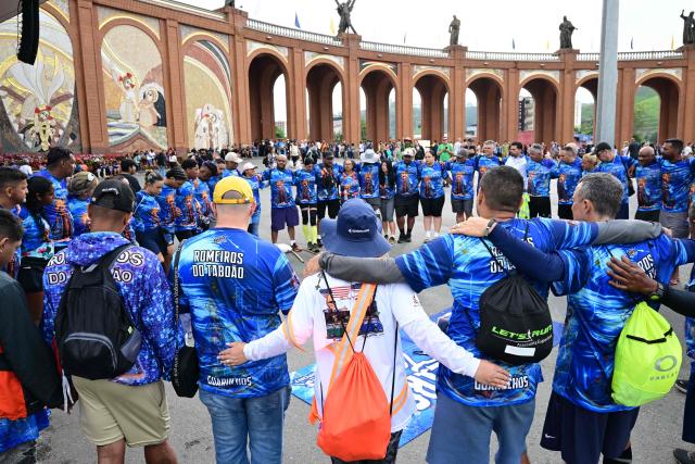Catholic devotees pray upon their arrival for celebrations marking Our Lady of Aparecida Day at the Basilica of the National Shrine of Our Lady of Aparecida, Brazil's patron saint, in Aparecida, Sao Paulo state, Brazil, on October 12, 2026. (Photo by Pablo PORCIUNCULA / AFP)