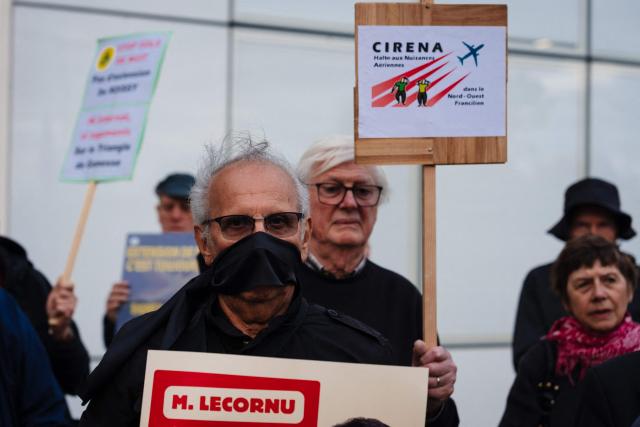 Protesters hold placard during a rally organised by the "Rester sur Terre" network and non-profit organization ADVOCNAR, to protest against the project to extend the Paris Charles de Gaulle Airport, in Roissy-en-France, near Paris on October 12, 2026. (Photo by Dimitar DILKOFF / AFP)