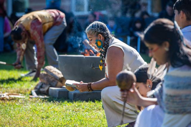 A woman reads a prayer during the opening ceremony of an Indigenous People's Day event in Newton, Massachusetts, October 12, 2026. (Photo by JOSEPH PREZIOSO / AFP)