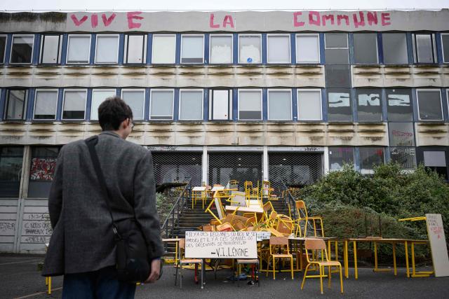 A student stands in front of the blocked entrance to a building at the University of Rennes 2, in Rennes on October 12, 2026. (Photo by Loic VENANCE / AFP)