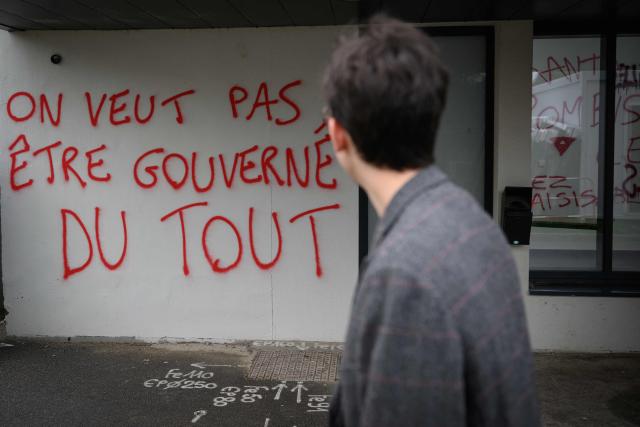 A student walks past a graffiti reading "We don’t want to be governed at all" on a wall of a building in the Rennes 2 university, on october 12, 2026. (Photo by Loic VENANCE / AFP)