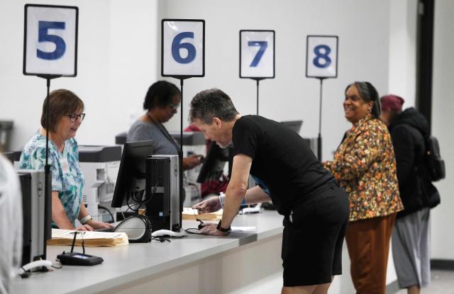 People recieve their ballots ahead of voting for the United States midterm election at the Summit County Board of elections in Akron Ohio on 12 October, 2026. Americans voting in the November 3 midterm elections will decide who controls Congress for the final two years of Donald Trump's presidency, along with dozens of governorships and thousands of state offices. (Photo by David MAXWELL / AFP)