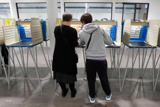 Voters fill out their ballots for the United States midterm election at the Summit County Board of elections in Akron, Ohio, on October 12, 2026. Americans voting in the November 3 midterm elections will decide who controls Congress for the final two years of Donald Trump's presidency, along with dozens of governorships and thousands of state offices. (Photo by David MAXWELL / AFP)