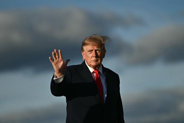 US President Donald Trump waves as he walks to board Air Force One at Joint Base Andrews, Maryland, on October 12, 2026. Trump is traveling to Youngstown, Ohio, to hold a campaign rally ahead of the midterm elections. (Photo by Kent NISHIMURA / AFP)