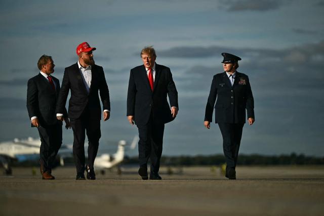 US President Donald Trump walks alongside US boxer and influencer Jake Paul before boarding Air Force One at Joint Base Andrews, Maryland, on October 12, 2026. President Trump is traveling to Youngstown, Ohio, to hold a campaign rally ahead of the midterm elections. (Photo by Kent NISHIMURA / AFP)