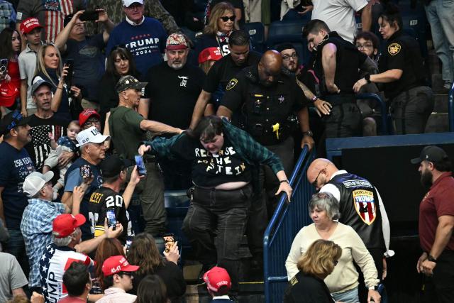 A protester is removed from the venue while US President Donald Trump speaks during a campaign rally at the Covelli Centre in Youngstown, Ohio, on October 12, 2026. (Photo by Kent NISHIMURA / AFP)