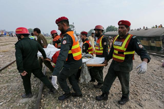 Rescue personnel carry the body of a person following the derailment of passenger train Rehman Baba Express on the outskirts of Multan on October 13, 2026. (Photo by Shahid Saeed MIRZA / AFP)
