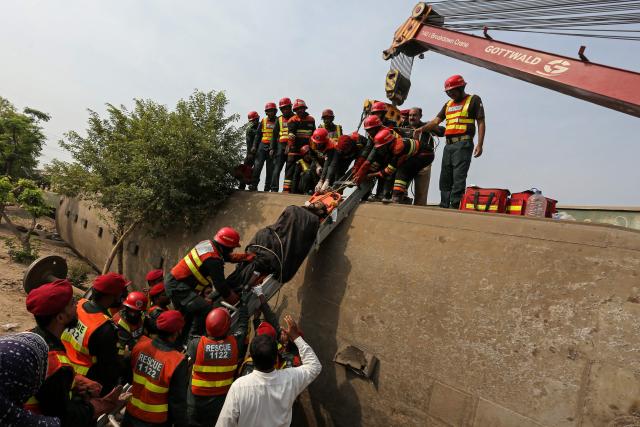 Rescue personnel carry an injured victim following the derailment of passenger train Rehman Baba Express on the outskirts of Multan on October 13, 2026. (Photo by Shahid Saeed MIRZA / AFP)