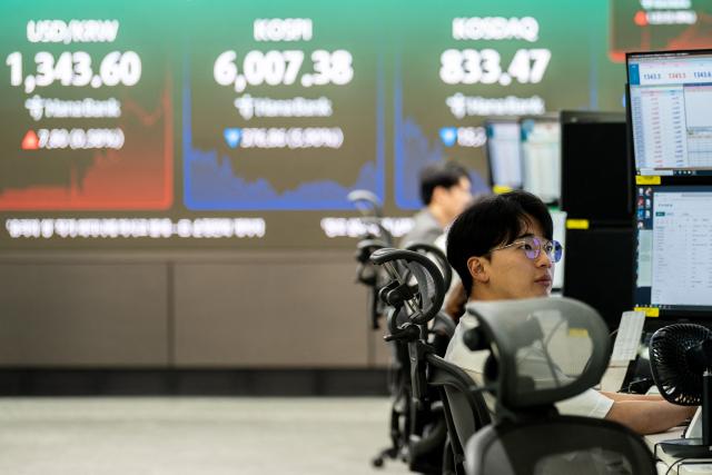 Dealers work near an electronic screen showing South Korea's benchmark stock index (KOSPI) in a dealing room at the Hana Bank headquarters in Seoul on October 13, 2026. Seoul, Tokyo and Taipei led losses across Asian stock markets on October 13 as technology firms plunged on fresh worries about the outlook for the AI investment boom, with traders preparing for a crucial earnings season and release of key US data. (Photo by Philip FONG / AFP)